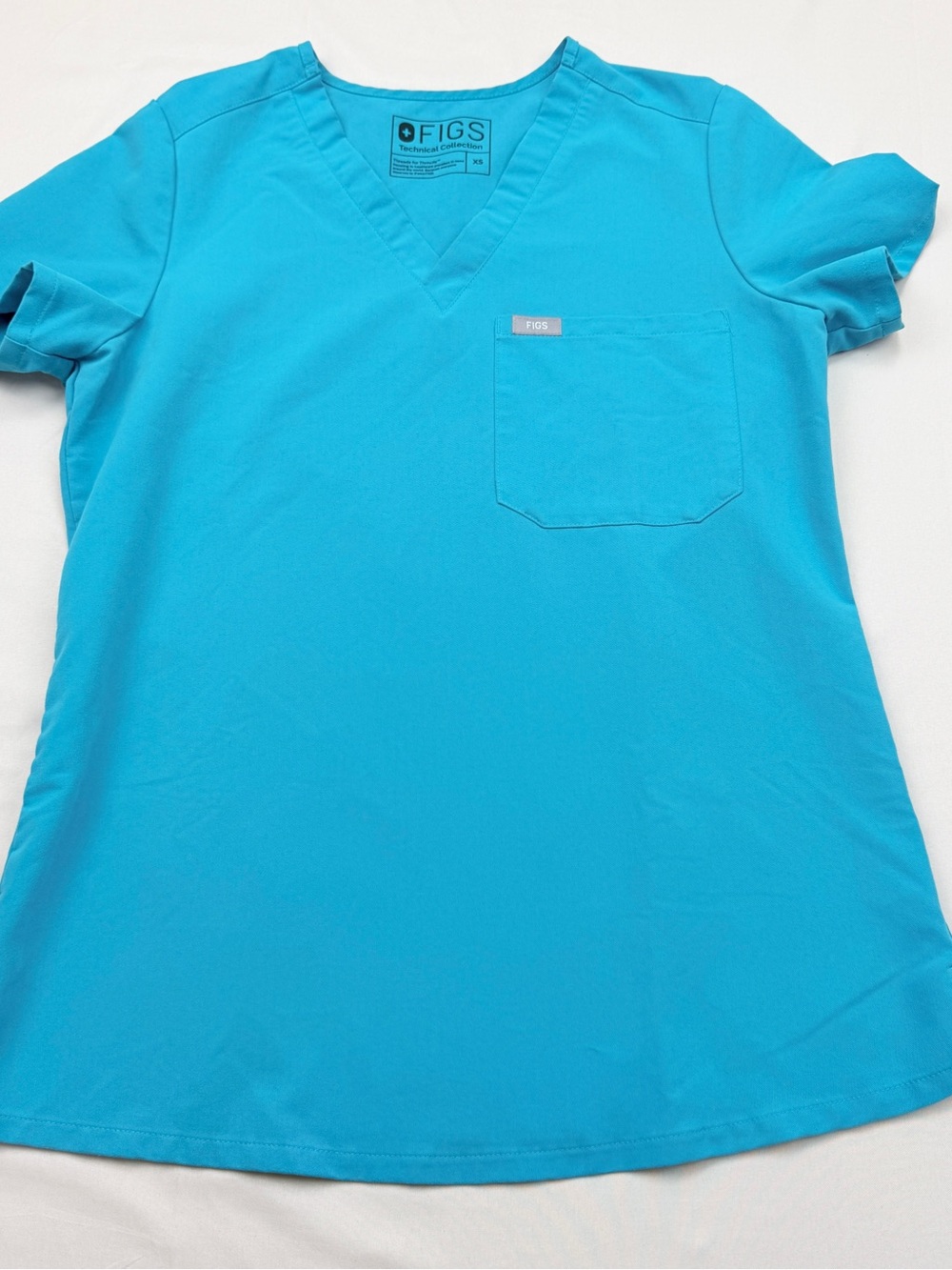 FIGS Catarina scrub top in a teal blue